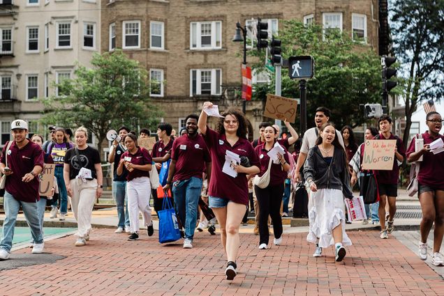Photo: A group of striking student RAs on Boston University's campus holding picket signs on a cloudy day