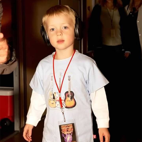 Photo: A child wearing large headphones with a cassette tape on a string around their neck