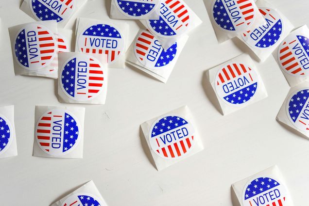 Photo: Many small, round stickers with an American flag print that say "I Voted" in blue text