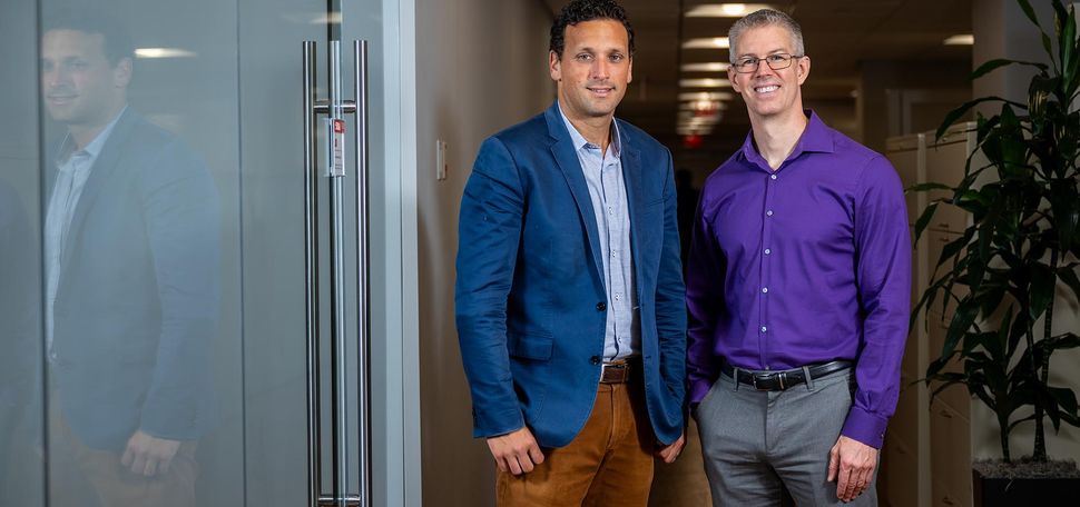 Photo: Michael Alosco, CTE Center codirector and associate professor of neurology, and Thor Stein, associate professor of pathology and laboratory medicine. Alosco wears a blue blazer and tan pants while Stein wears a purple shirt and gray pants.