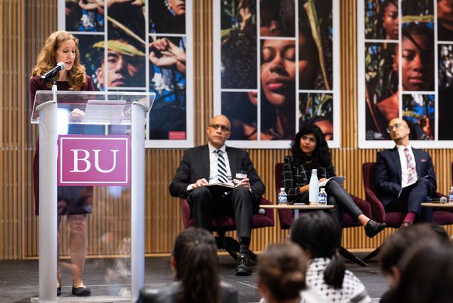 Photo: A picture of a panel with a woman standing behind a podium that says "BU" on it