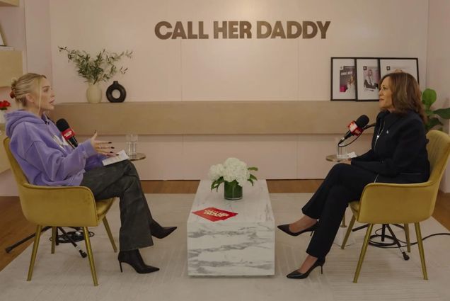 Photo: A screenshot from a "Call Her Daddy" podcast in which Alex Cooper, sitting on a chair on the left, is talking with Vice President Kamala Harris, who is on the right.