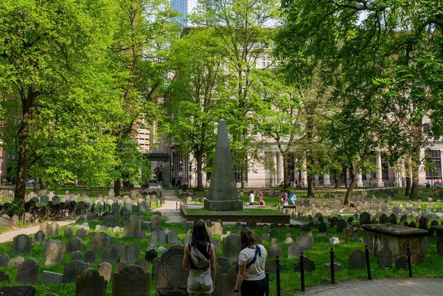 Photo: Two young women standing in a cemetery on a sunny day