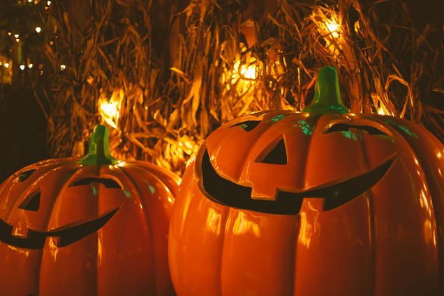 Photo: Two Jack O'Lanterns in front of hay.