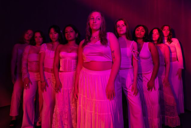 Photo: BU's Trebelmakers pose in a V-formation under pink, artistic lighting.