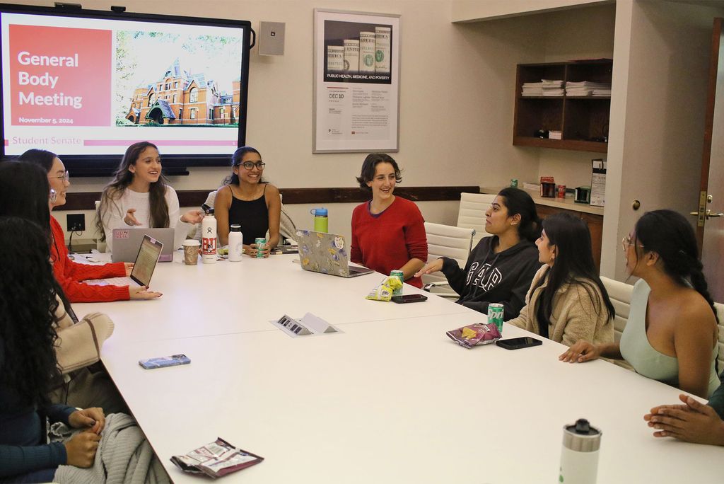 Photo: A group of people having a discussion around a large table