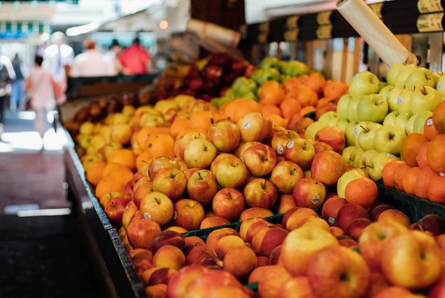 Photo: A row of fruits, with a majority of apples in the front.
