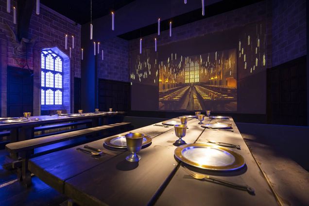 Photo: A room in Harry Potter: The Exhibit which features a recreation of the Great Hall, with long dining room tables and floating candles