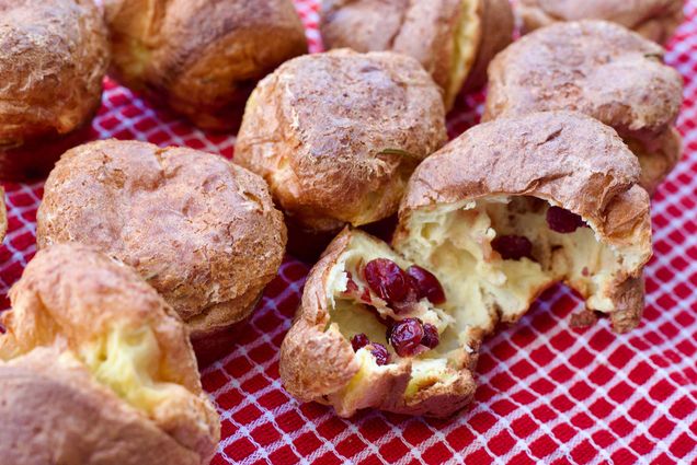 Photo: A plate of cranberry and rosemary popovers on a red and white squared tablecloth