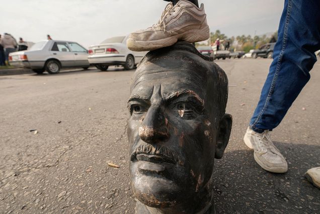 Photo: A statue of late dictator Hafez Assad stepped on by a Syrian rebellion leader.