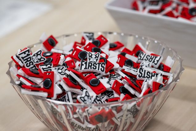 Photo: A bowl of Pins that say "Firsts" with a BU Boston Terrier logo