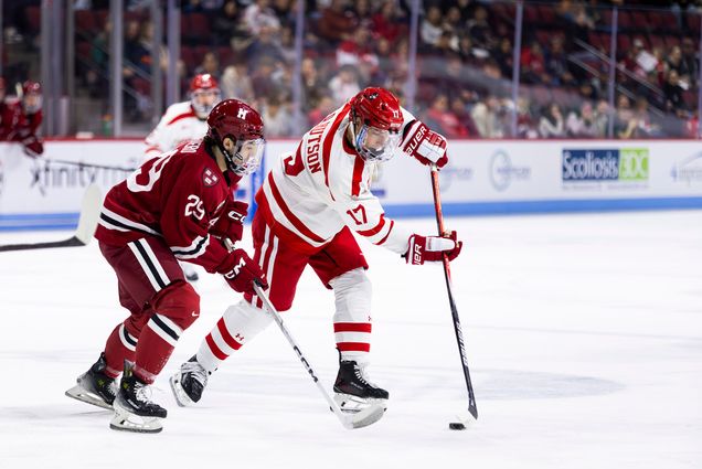 Photo: Two hockey players on the ice, with the Boston University one in possession of the puck