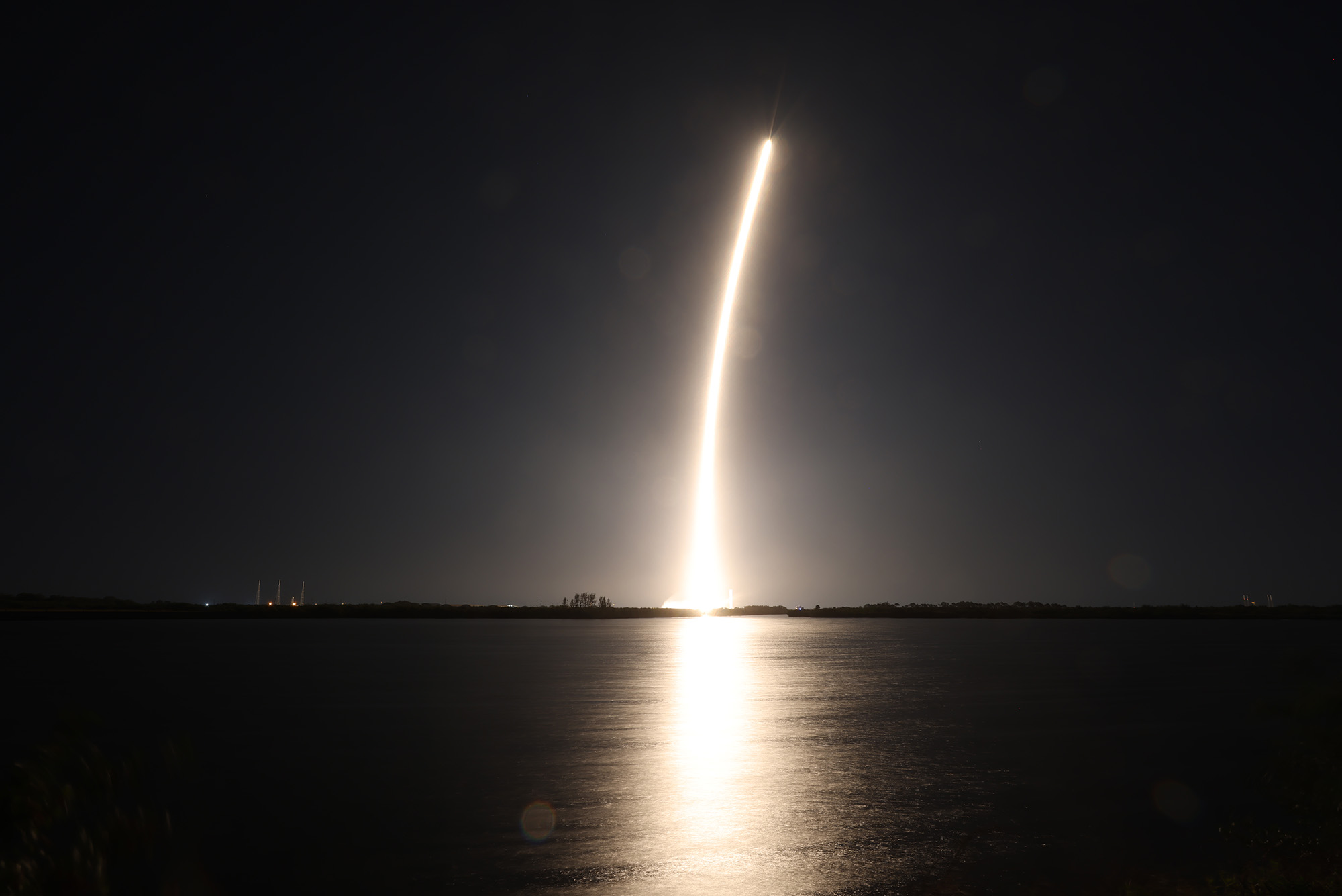 Photo: A rocket blasting off into space over the water.