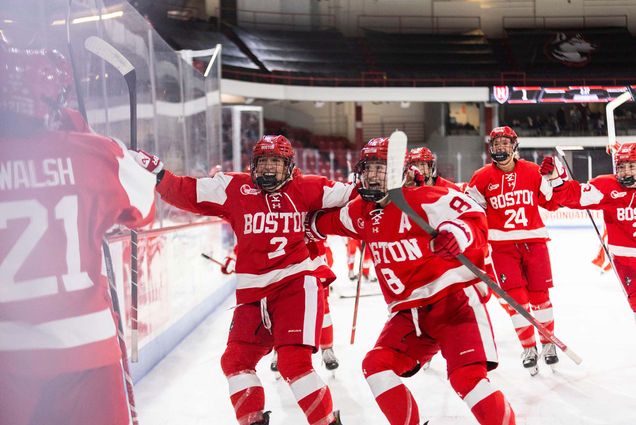 Photo: BU Women's Hockey celebrating their win in the Women's Beanpot Semifinals. They are hugging one another and smiling widely