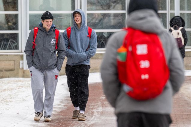 Photo: A couple of BU students stroll in the snow, kept warm by their all-gray sweatsuit.