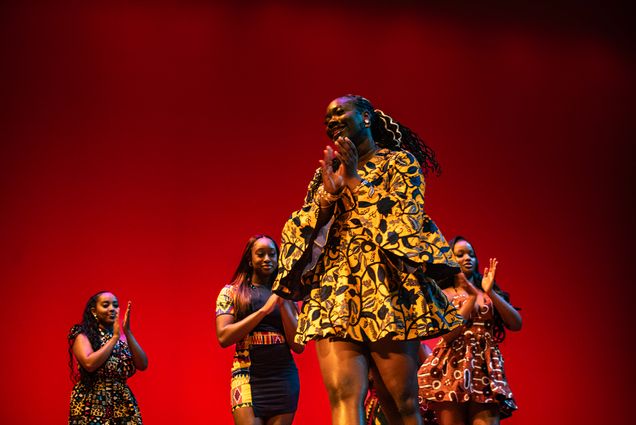Photo: Four Black female students walk in a fashion show with a red backdrop behind them