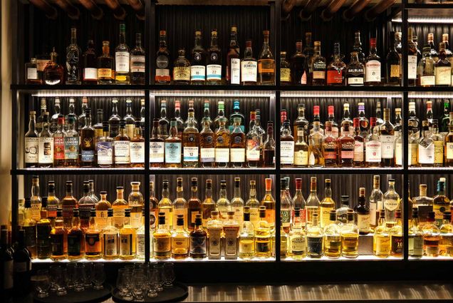 Photo: A stock photo of various whiskey bottles on shelves in a bar.