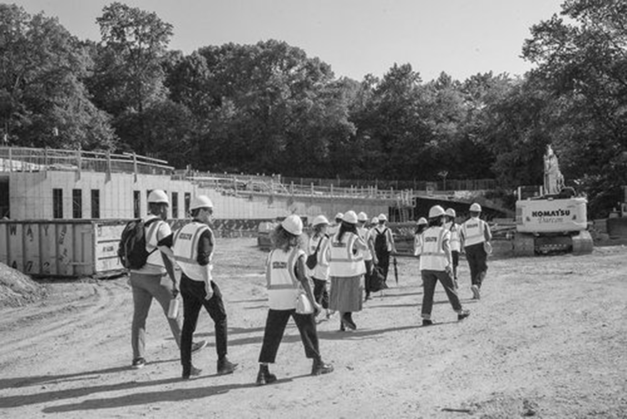 Photo: A group of people in hi-vis vests walk together in a pack