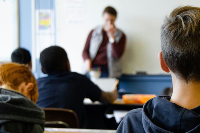 Photo: A classroom full of students watching their teacher speak