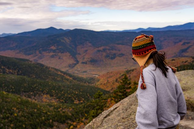 Photo: A BU student looking off into the distance from atop a mountain in a range