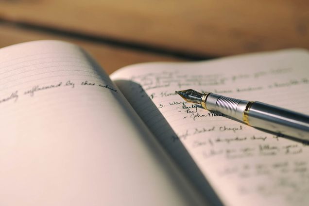 Photo: A stock image of a fountain pen on a journal.
