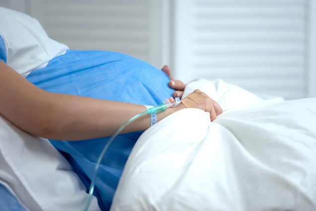 Photo: A pregnant woman laying in a hospital bed