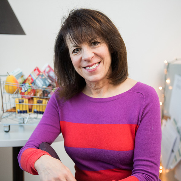 Photo: A woman with short dark hair poses for a portrait wearing a brightly colored shirt