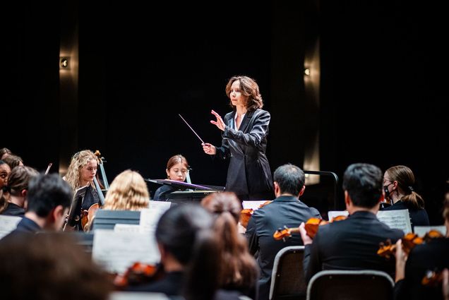 Photo: Sarah Ioannides, BU's new director of orchestral activities, conducting an orchestra on stage