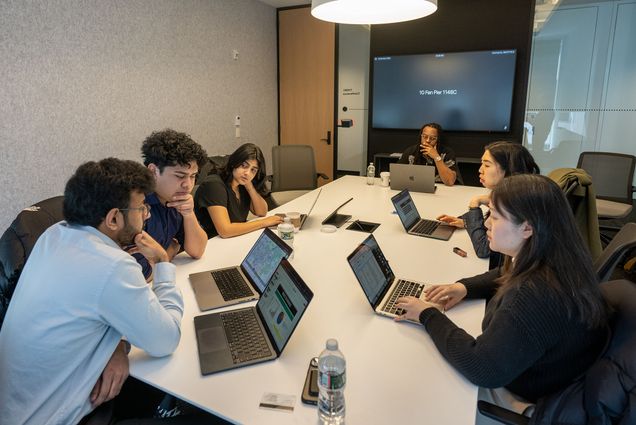 Photo: People at a table with their laptops open