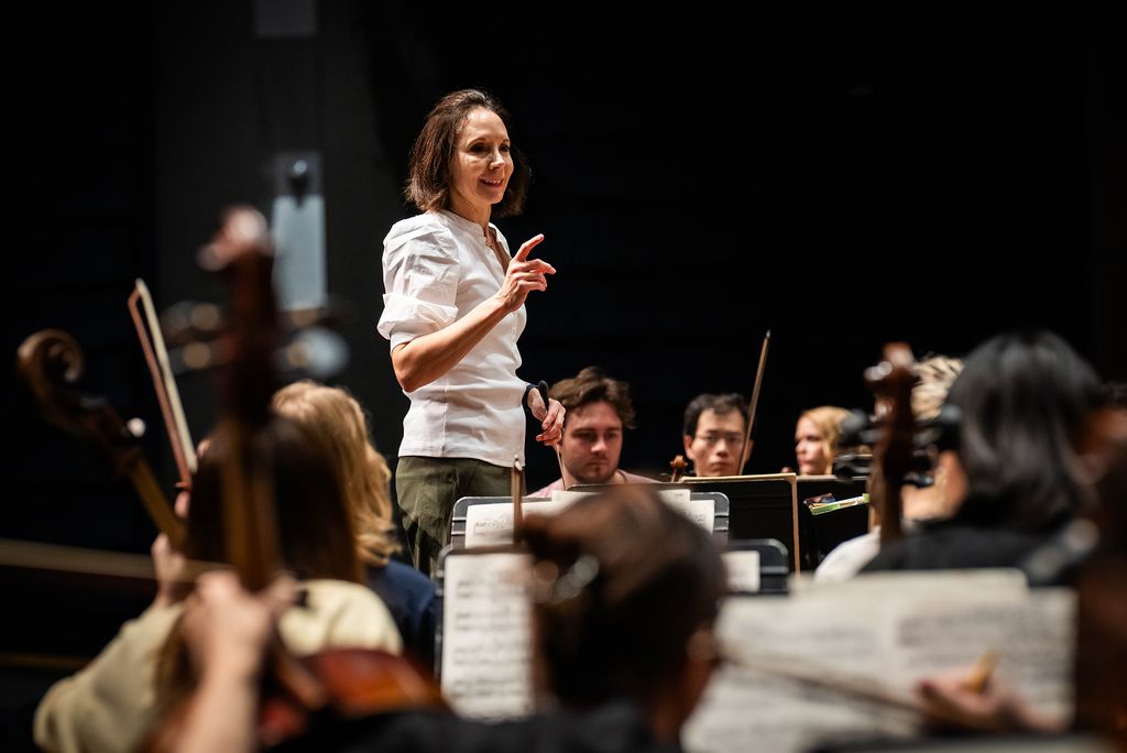Photo: Sarah Ioannides, BU's new director of orchestral activities, conducting an orchestra on stage