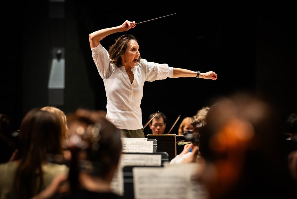 Photo: Sarah Ioannides, BU's new director of orchestral activities, conducting an orchestra on stage
