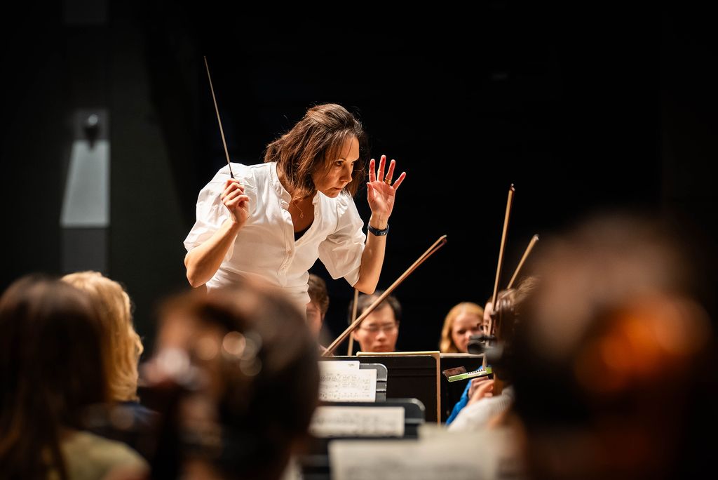 Photo: Sarah Ioannides, BU's new director of orchestral activities, conducting an orchestra on stage