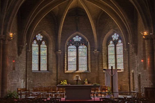 Photo: A stock image of an empty church with three stain glass windows.
