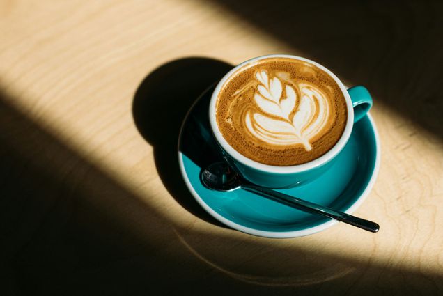 Photo: A dramatic photo of latte art in a teal cup.