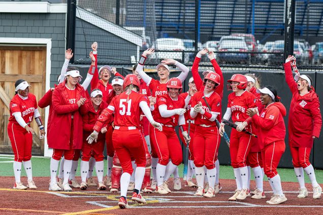 Photo: BU Women's Softball team celebrates a runner as they arrive at home plate
