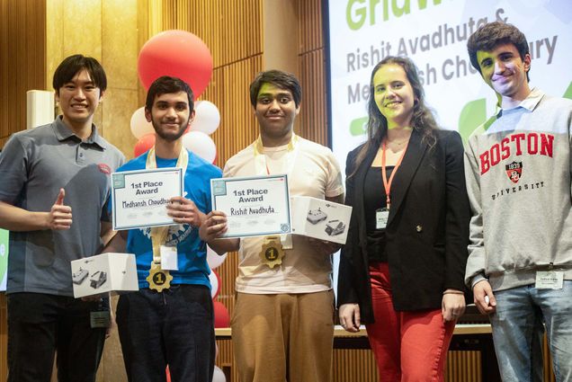 Photo: Five people pose for a photo with various certificates and medals after winning a college event.