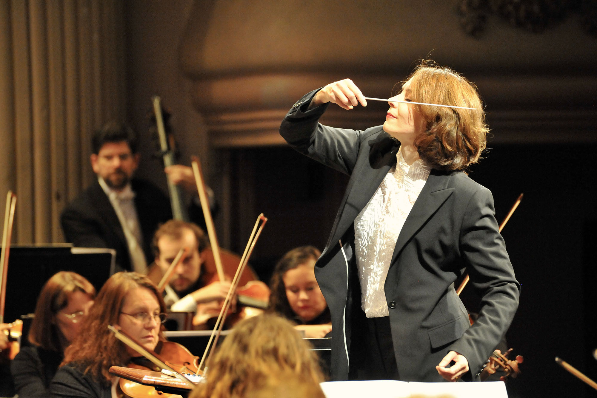 Photo: Sarah Ioannides, BU's new director of orchestral activities, conducting an orchestra on stage