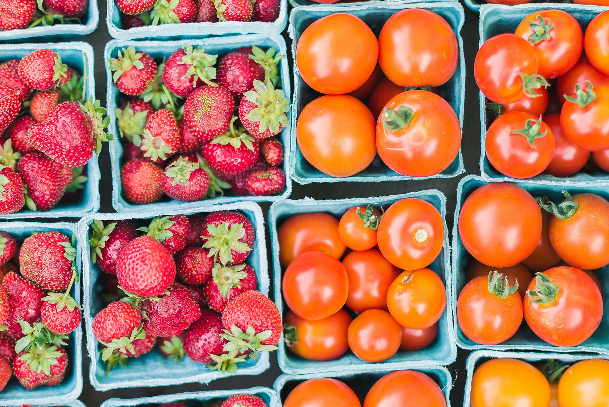 Photo: An overhead view of baskets of strawberries and tomatoes