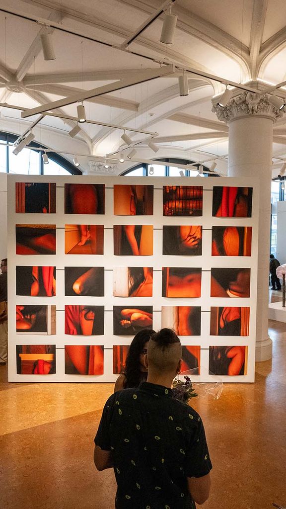 Photo: An exhibit from Boston University's MFA thesis exhibition. Thre are many red-toned prints hung on a wall