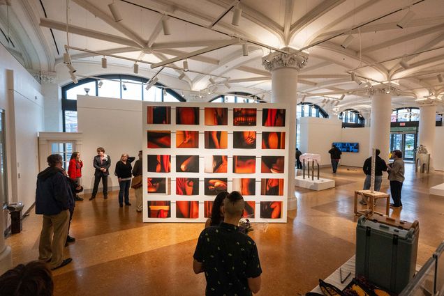 Photo: An exhibit from Boston University's MFA thesis exhibition. Thre are many red-toned prints hung on a wall