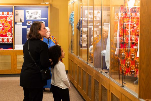 Photo: A Mother and her daughter view African Textiles in a display case.