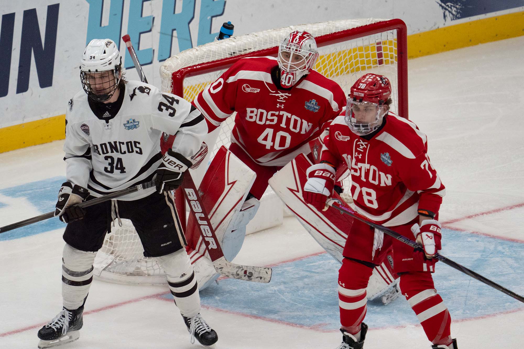 Photo: Hockey players, two from Boston University and one from Western Michigan, looking off the side on the ice with confusion