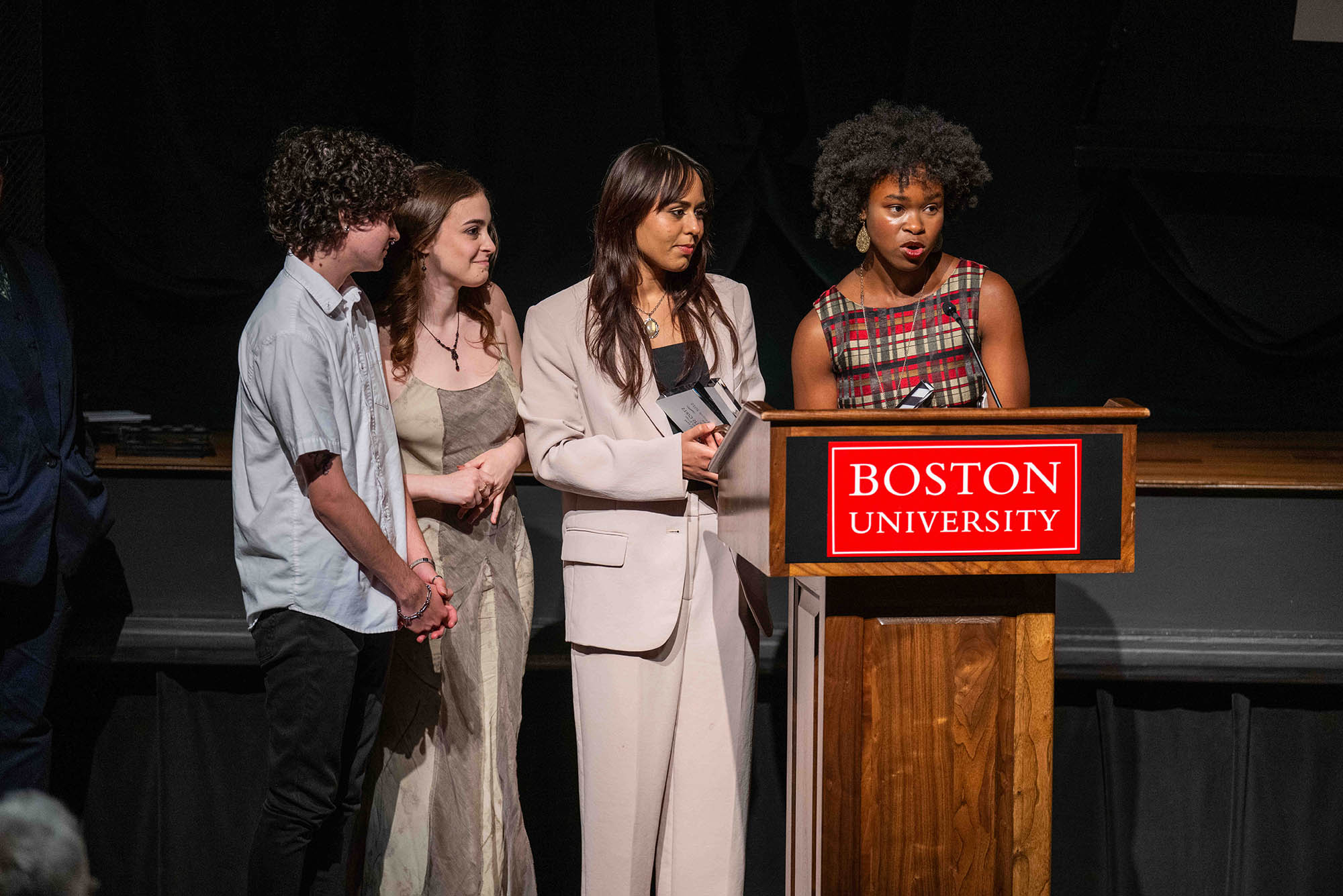 Photo: Four young individuals at a podium as they accept their award.