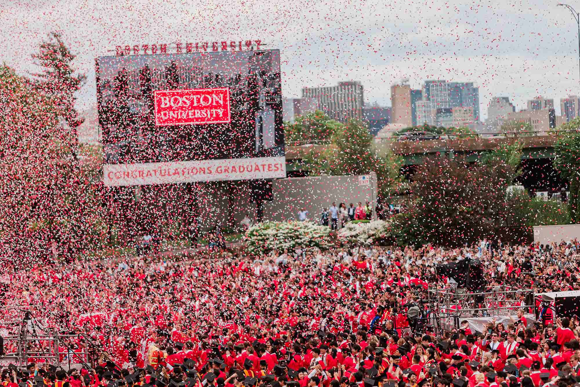 Photo: A wide shot of Nickerson Filed with confetti flying in the air. The large video board reads BOSTON UNIVERSITY CONGRATULATIONS GRADUATES!