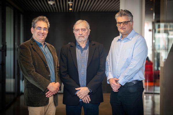 Photo: Three men stand with arms crossed as they pose for a formal portrait together