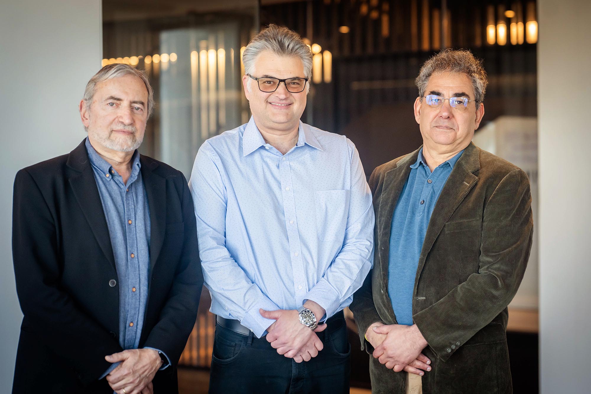 Photo: Three men stand with arms crossed as they pose for a formal portrait together