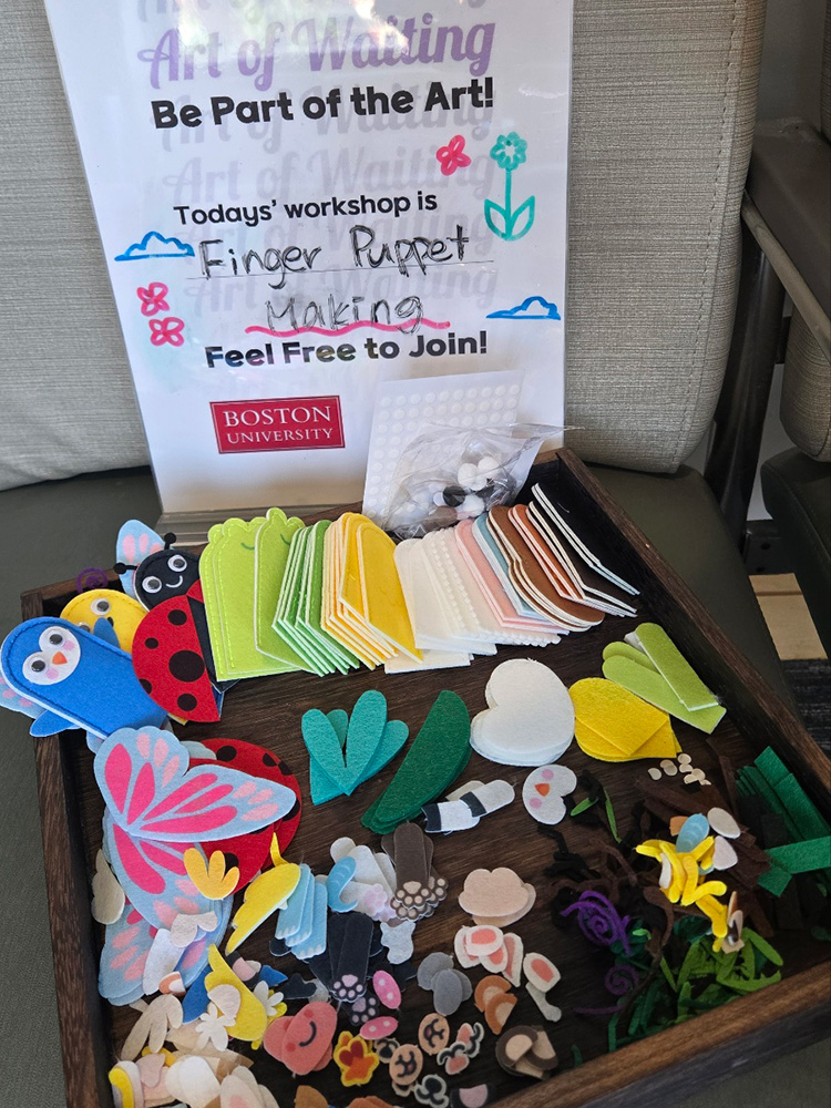 Photo: A collection of materials to make finger puppets under a sign that reads "Today's workshop is Finger Puppet making! Feel free to join"