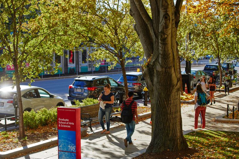 Students walking on sidewalk in fall