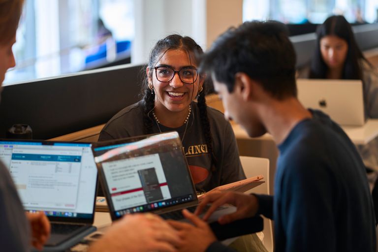 Students on laptops in the CDS