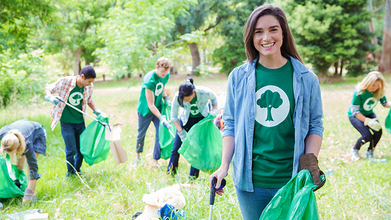 people gathering litter in a wooded area